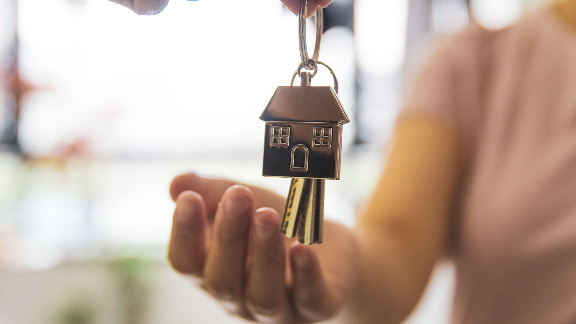 A person is holding a house key in their hand.