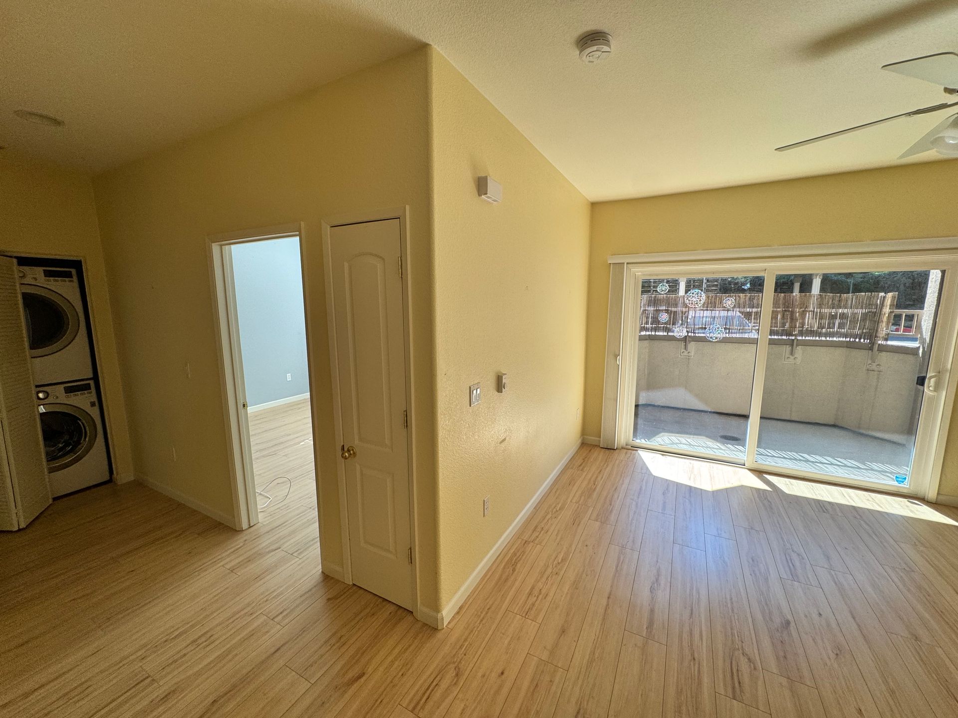 A living room with a sliding glass door and a washer and dryer.