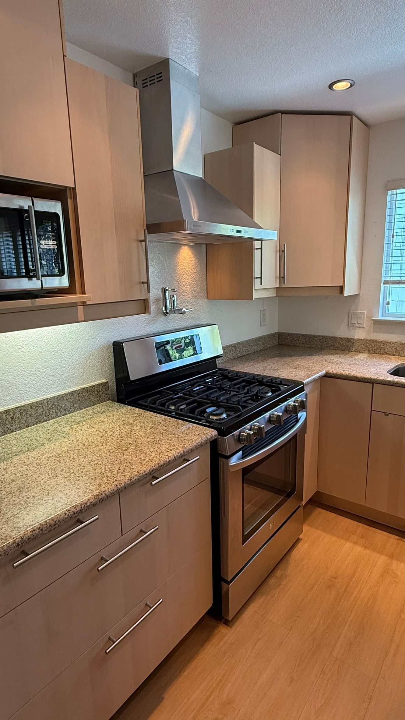 A kitchen with stainless steel appliances and granite counter tops.