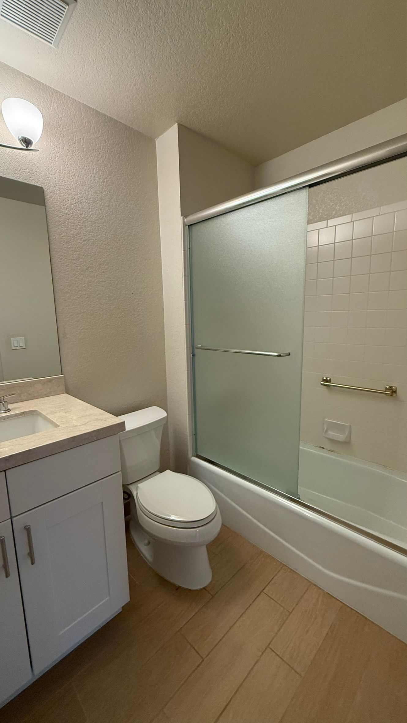 A bathroom with a toilet , sink , and bathtub.