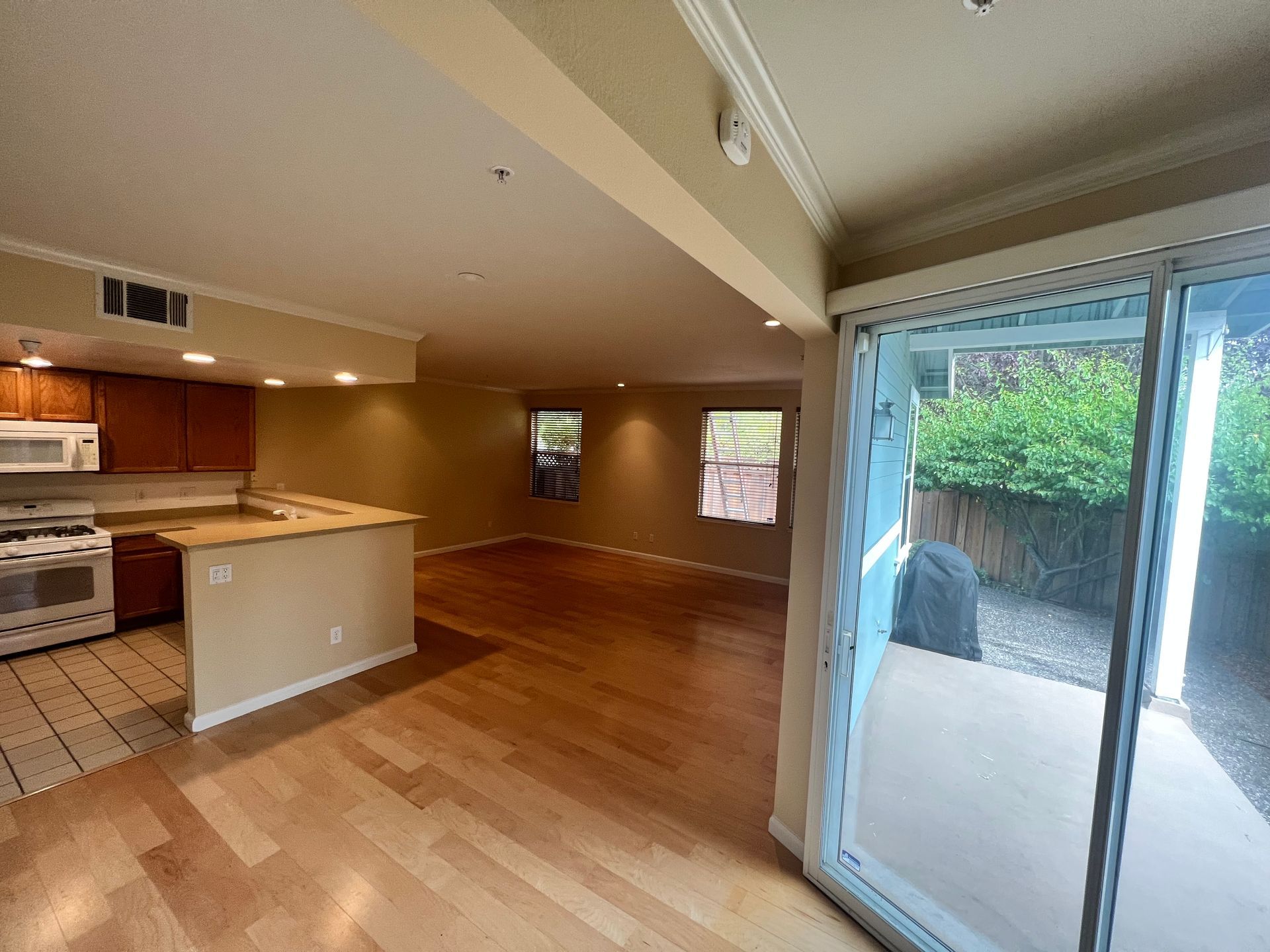 An empty kitchen with a sliding glass door leading to a patio.