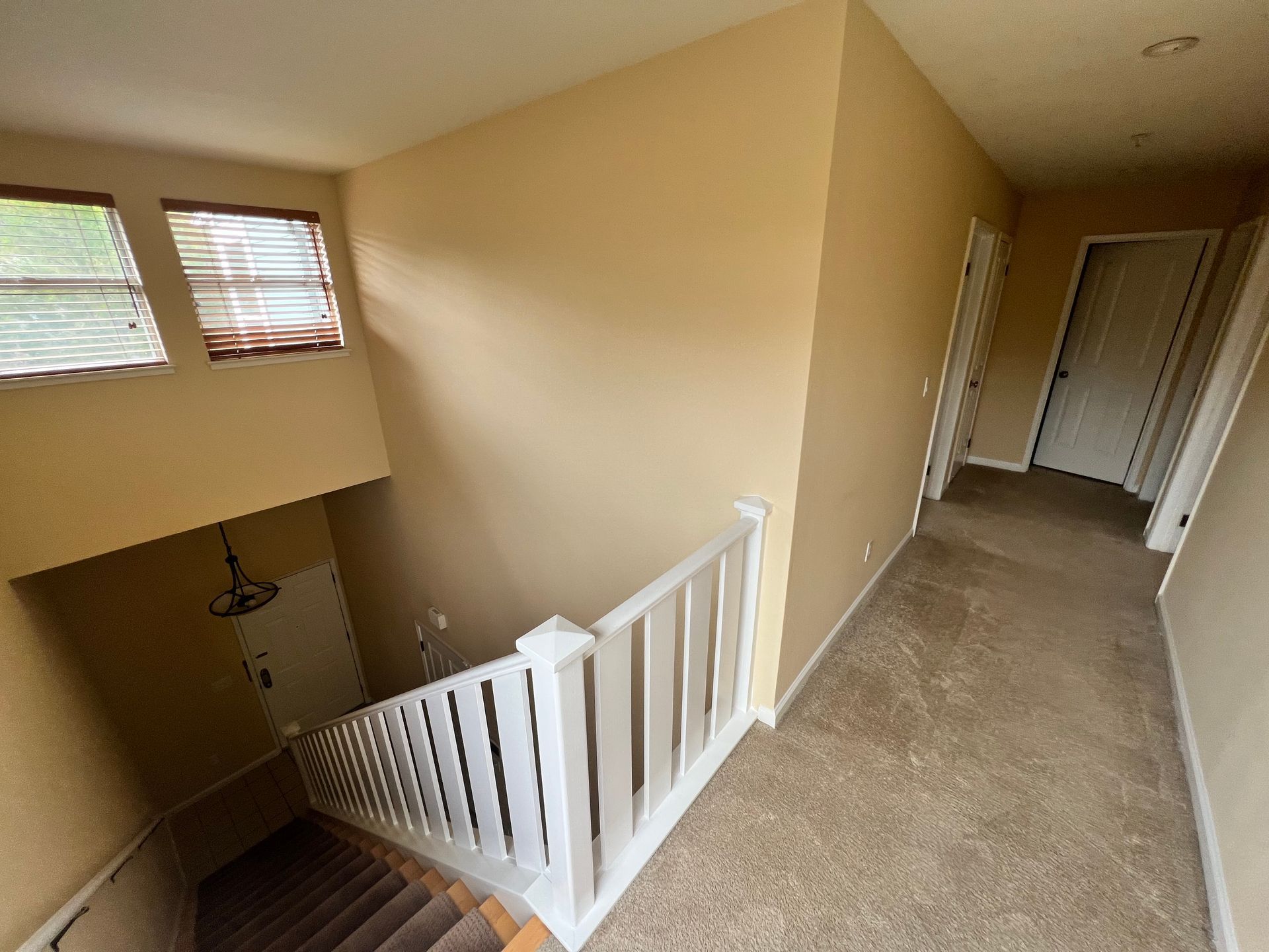 A hallway with stairs leading up to the second floor of a house.