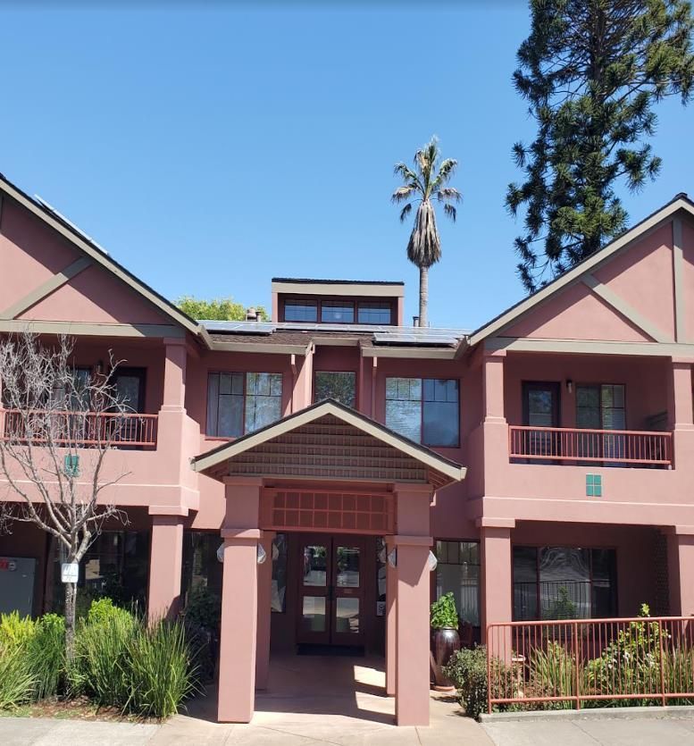 A large pink building with a palm tree in the background