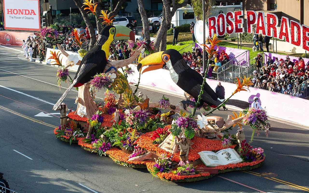 Rose Parade float with large toucan figures and flowers, Pasadena, CA.