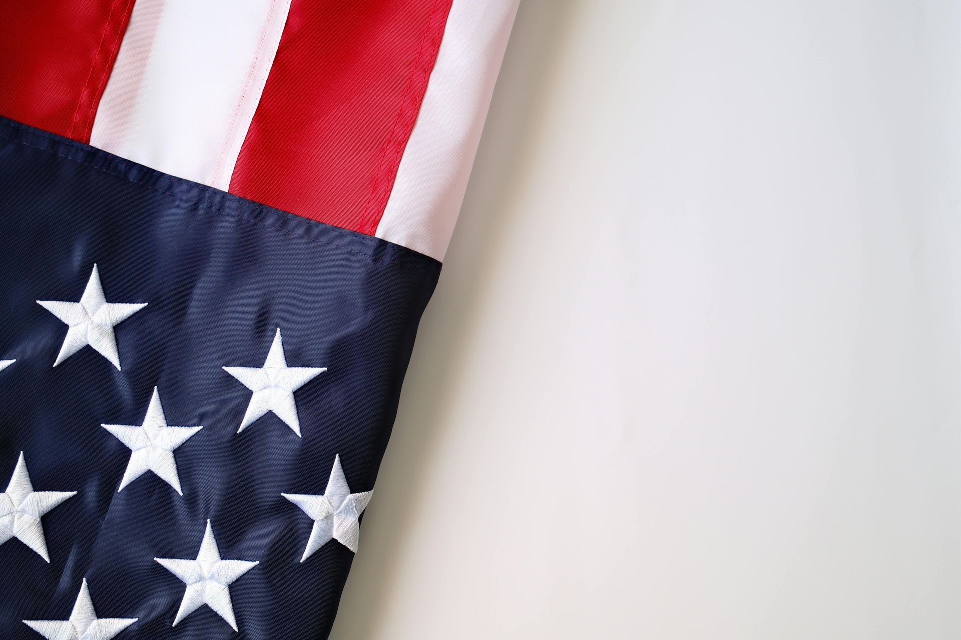 A close-up view of the folded corner of an American flag showing stars on a blue field and red and white stripes.