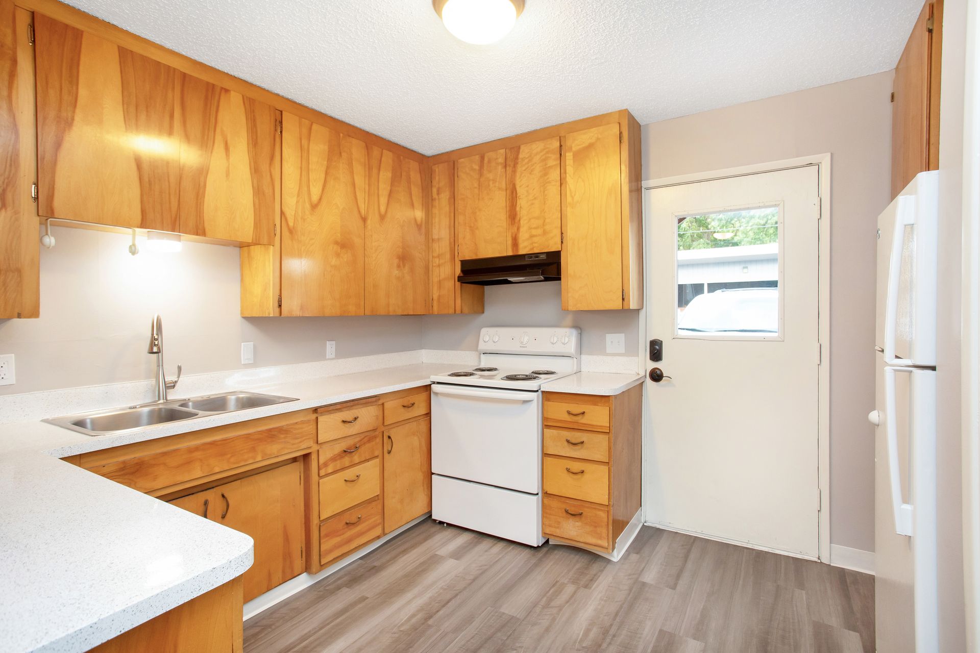 A kitchen with wooden cabinets and white appliances
