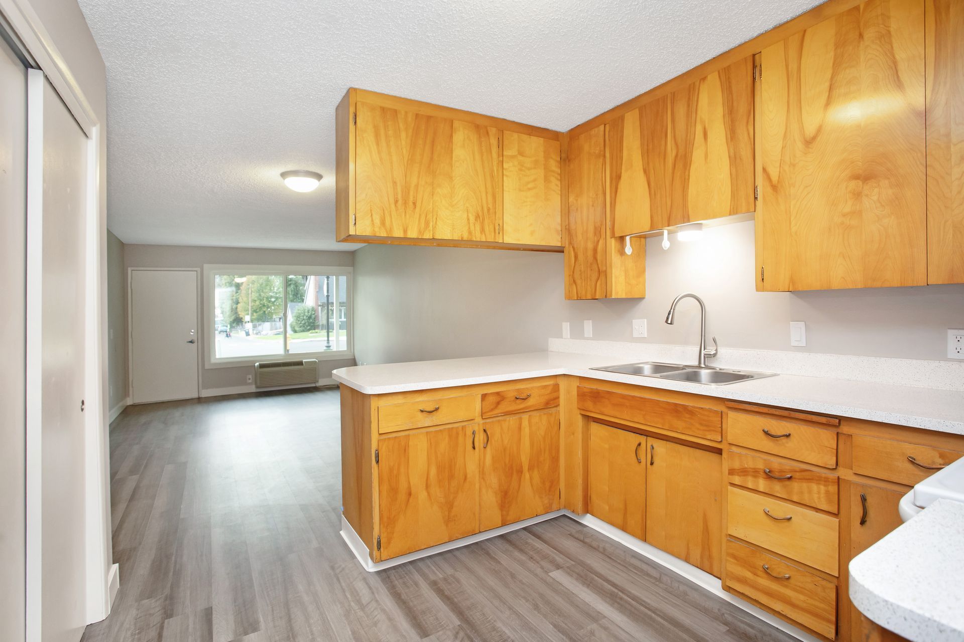 An empty kitchen with wooden cabinets and a sink