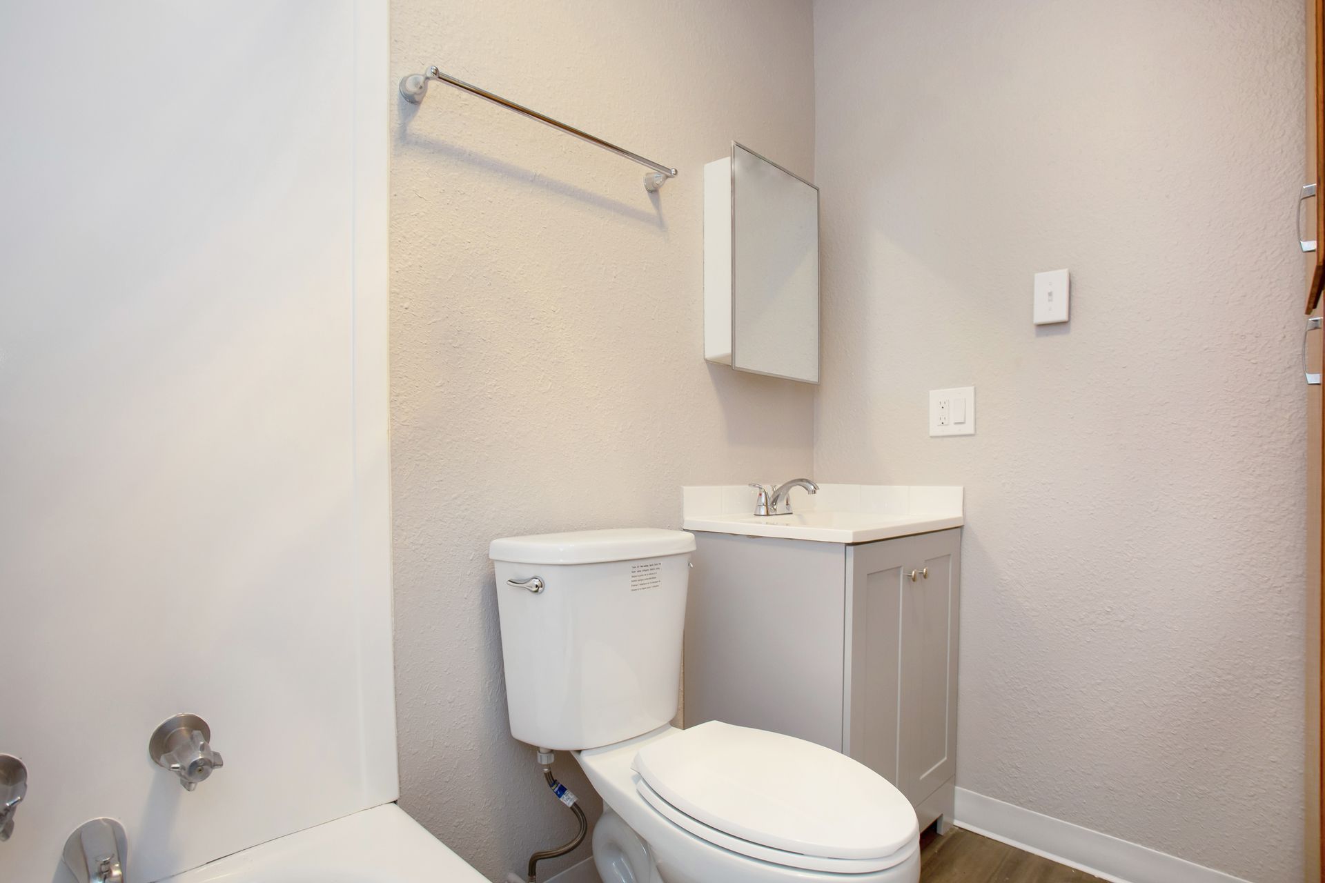 A bathroom with a toilet , sink , and bathtub.