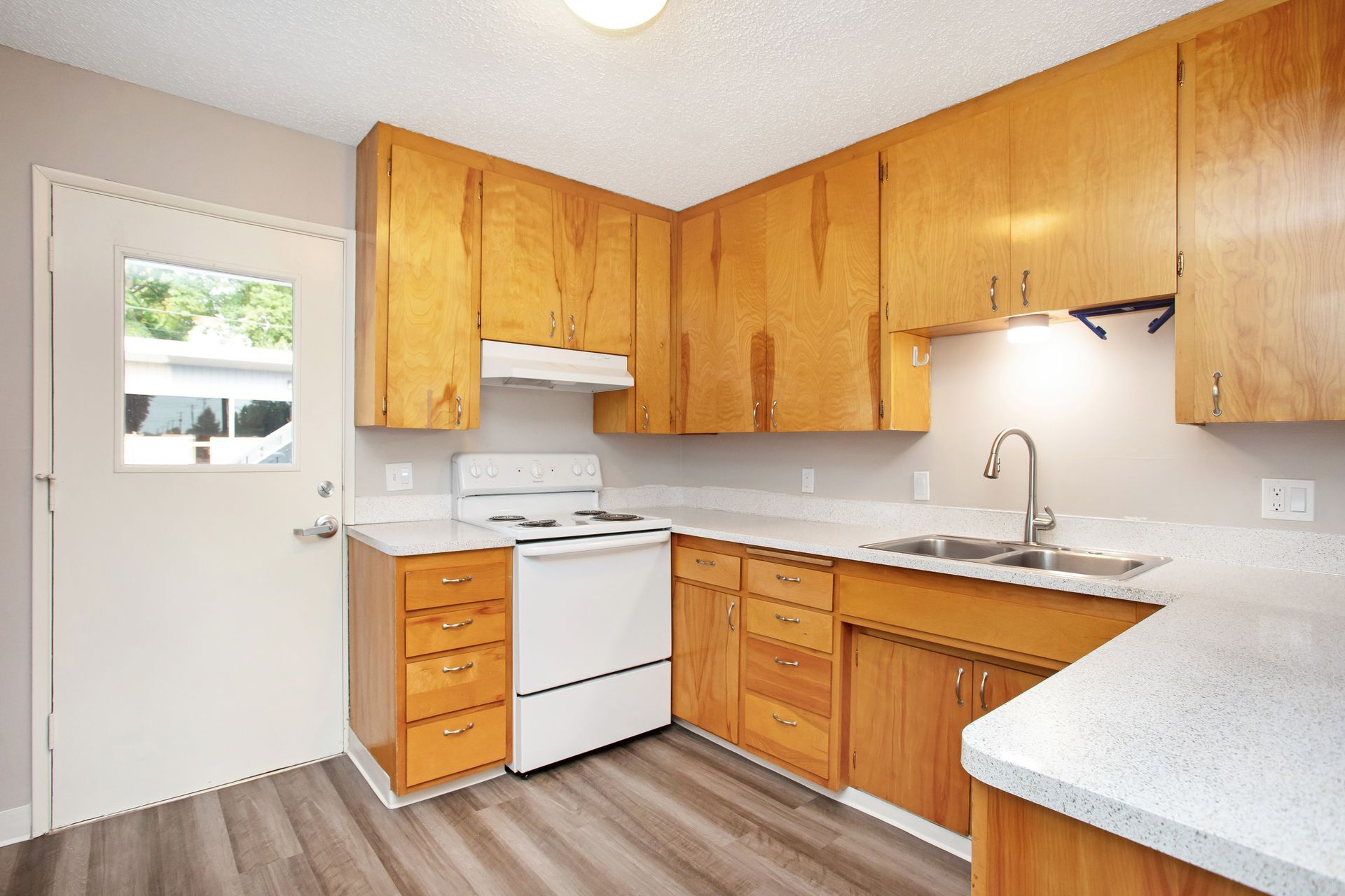 A kitchen with wooden cabinets and a white stove top oven