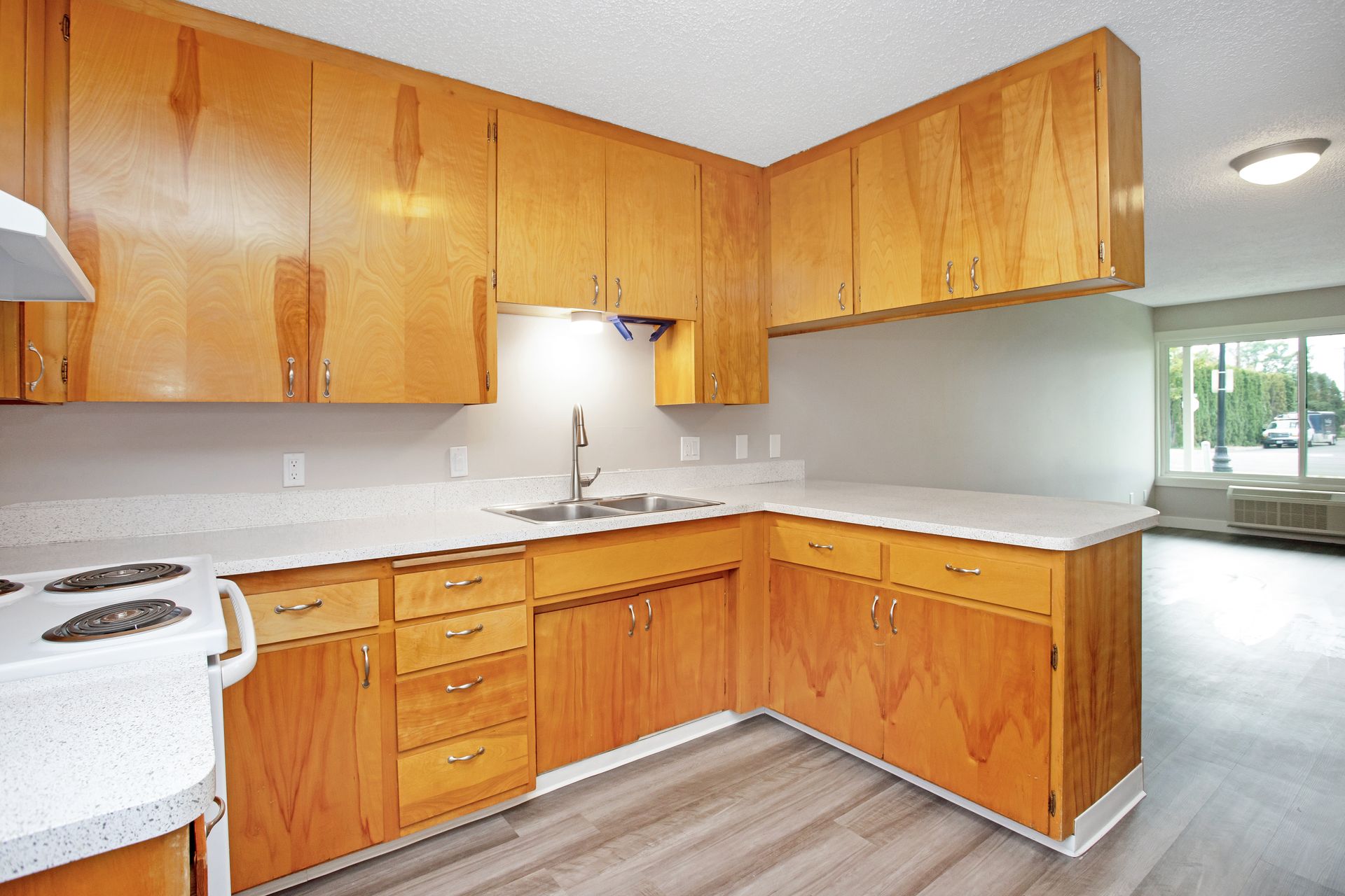 A kitchen with wooden cabinets and white counter tops