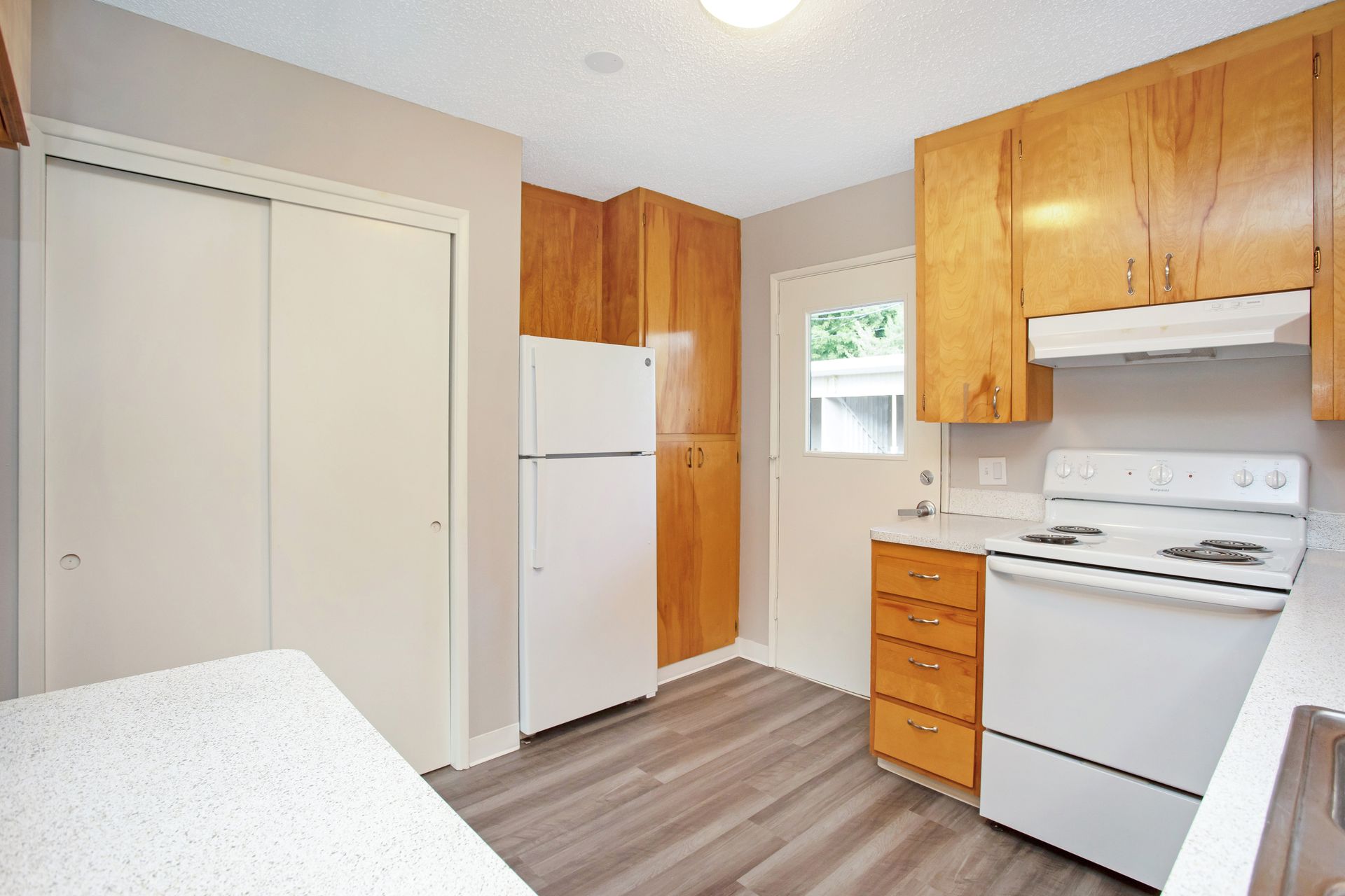 A kitchen with a stove , refrigerator , and cabinets