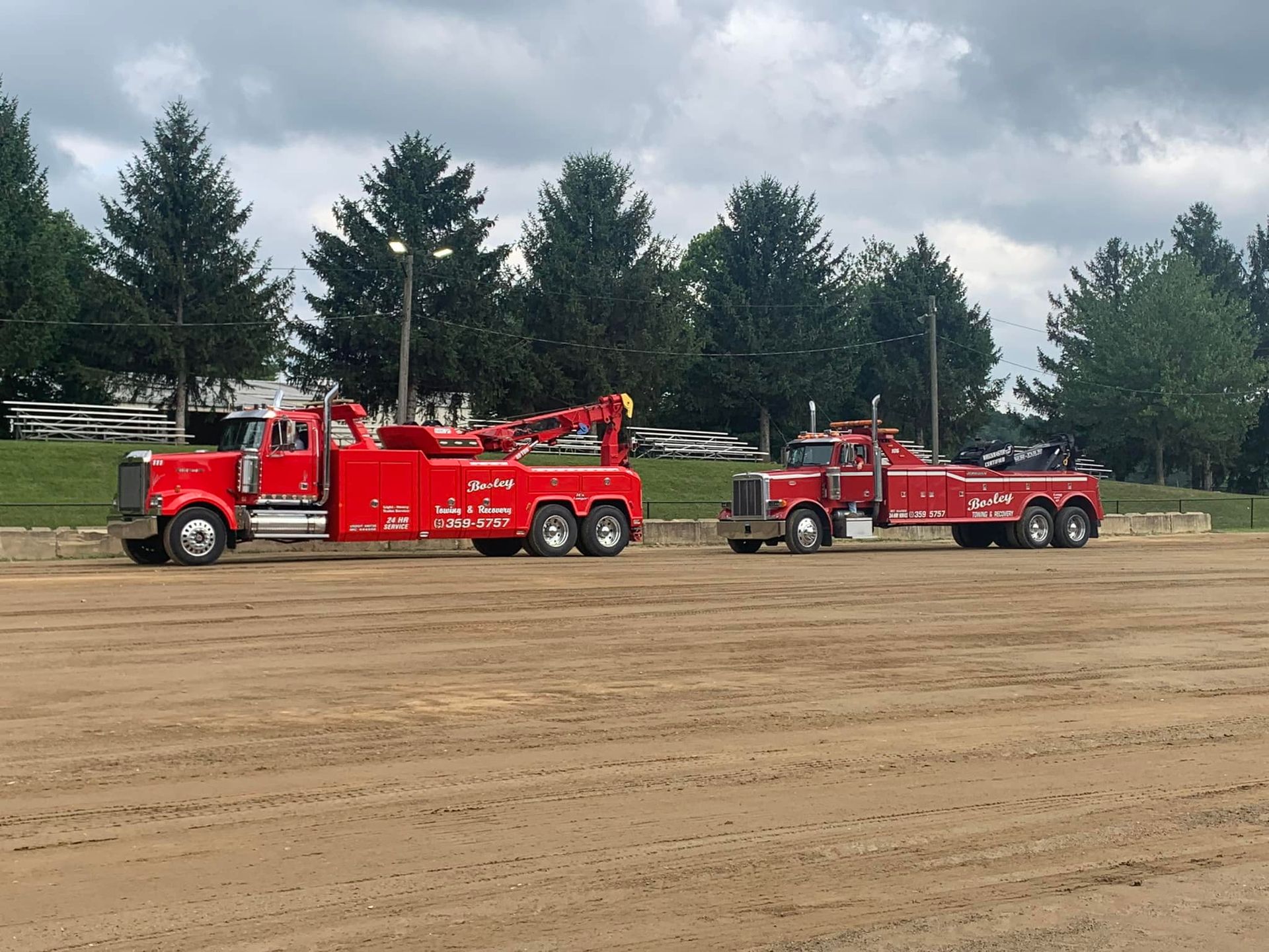 A man is towing a car on a tow truck.