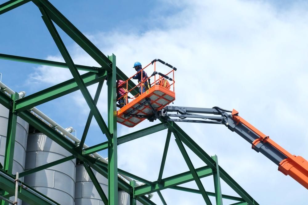 A Man Is Sitting in A Bucket on A Crane — AMAC Cranes in Caboolture, QLD