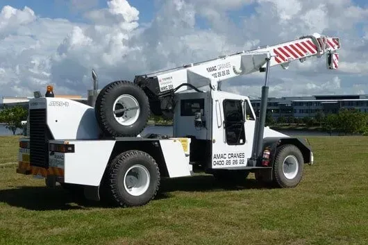 A Large Crane Is Sitting on Top of A Gravel Road at Sunset — AMAC Cranes in Coolum Beach, QLD