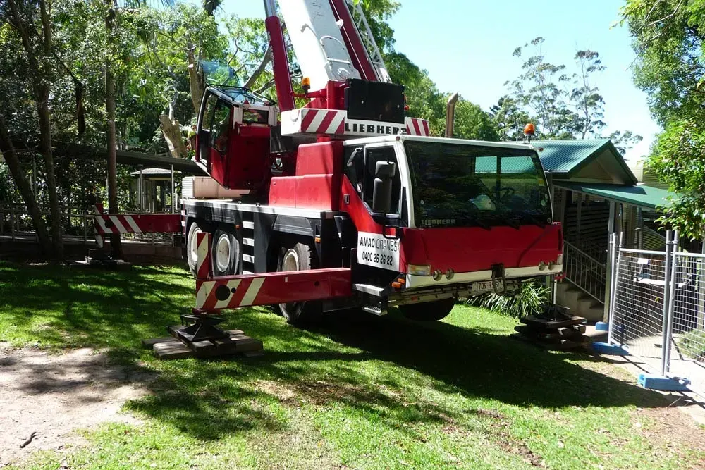 A Red and White Crane Is Parked in A Grassy Area — AMAC Cranes in Coolum Beach, QLD