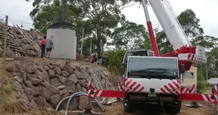 A Boat Is Being Lifted Into the Water by A Crane — AMAC Cranes in Coolum Beach, QLD