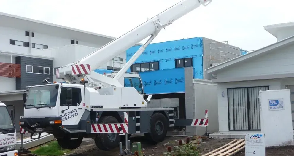 A White Crane Is Parked in Front of A Building Under Construction — AMAC Cranes in Coolum Beach, QLD