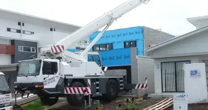 A Boat Is Being Lifted Into the Water by A Crane — AMAC Cranes in Coolum Beach, QLD