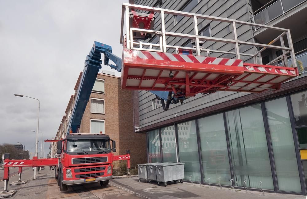 A Red Truck Is Parked in Front of A Building with A Crane Attached to It — AMAC Cranes in Coolum Beach, QLD