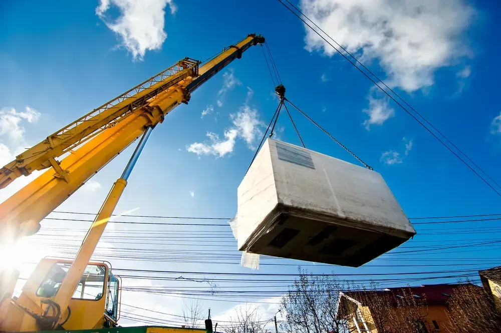 A Crane Is Lifting a Large Concrete Box Into the Air — AMAC Cranes in Coolum Beach, QLD