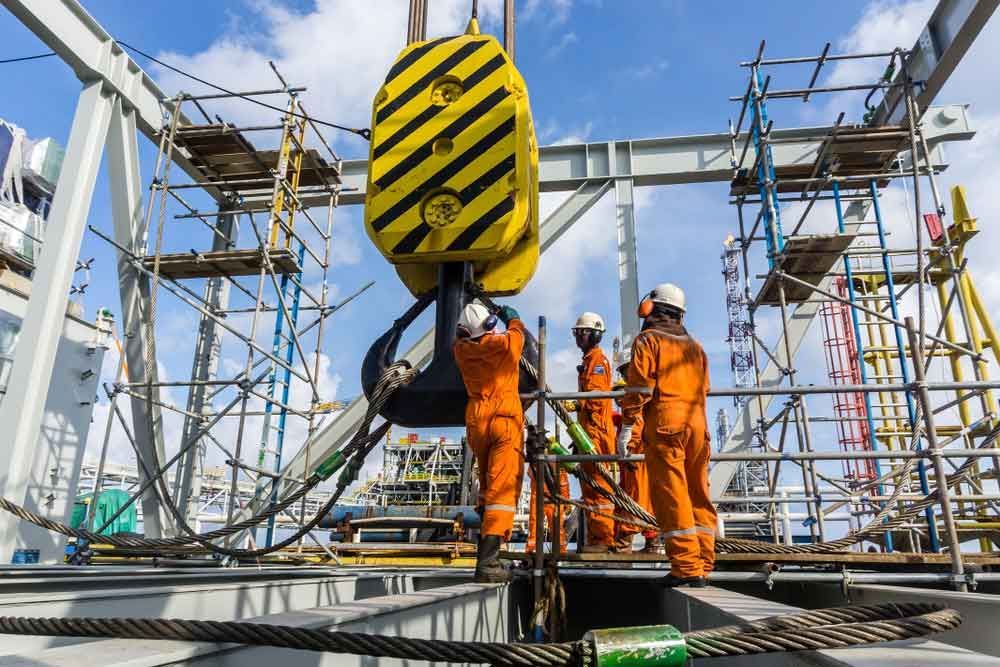 A Group of Construction Workers Are Working on A Large Crane — AMAC Cranes in Coolum Beach, QLD