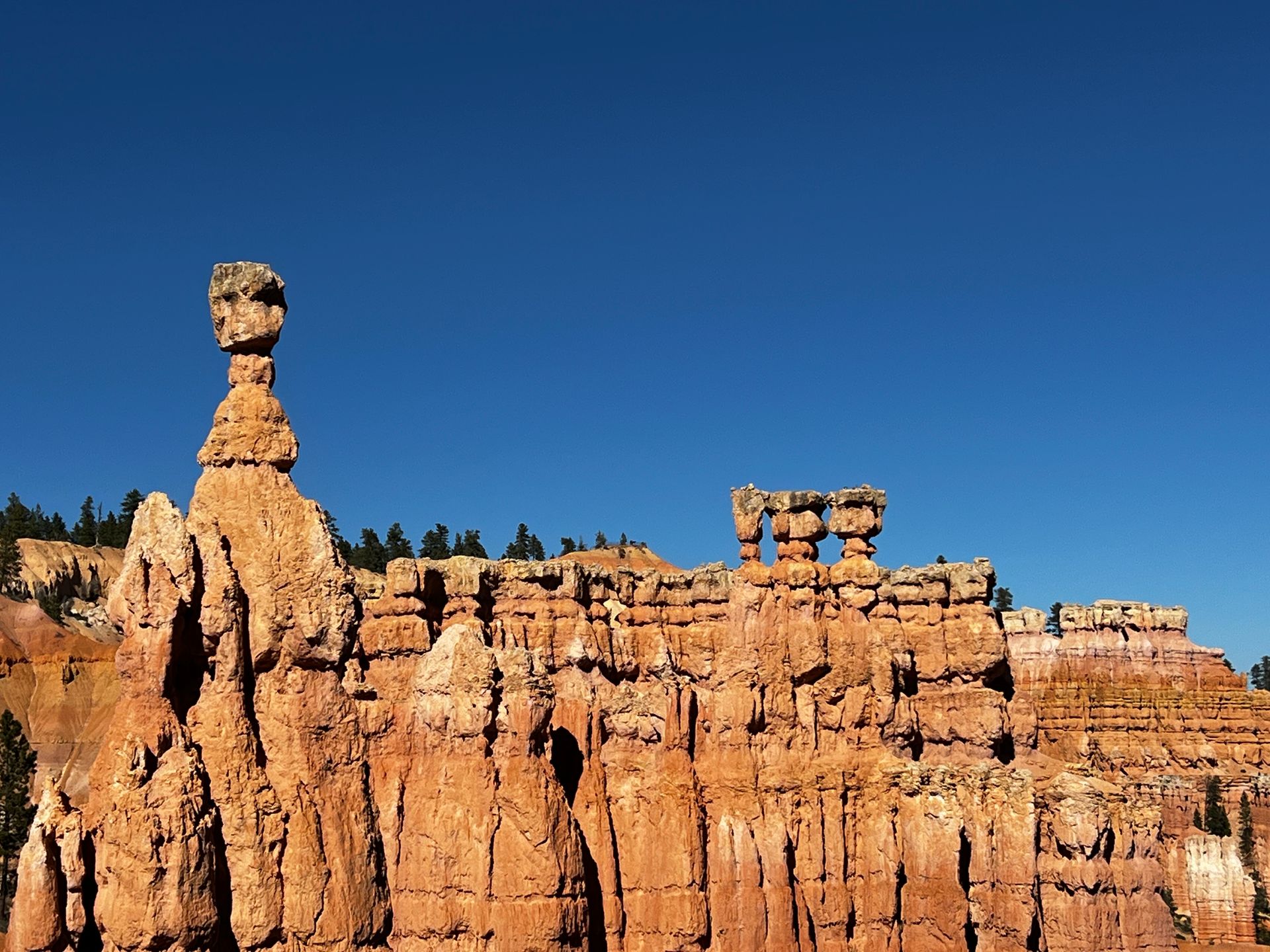 Orange rock formations under a clear blue sky, Bryce Canyon National Park, Utah.
