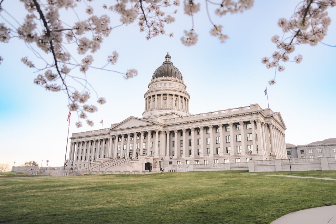 Winding mountain road with a snowy peak in the distance, autumn colors visible on the hillside.