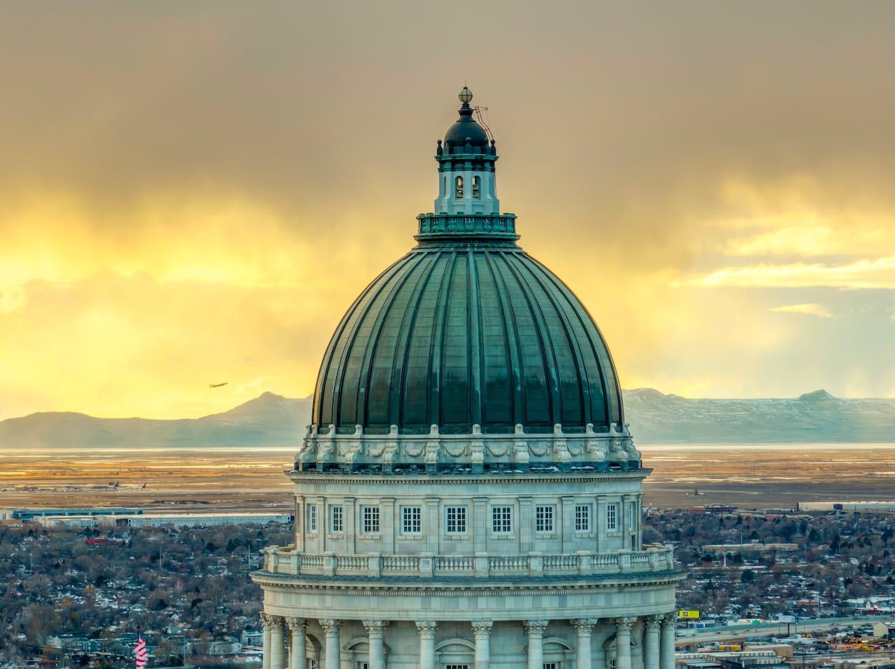 Utah State Capitol Building dome with sunrise in the background.