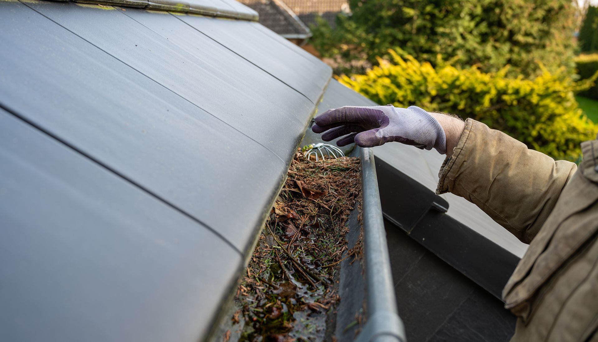 Construction blueprints, level, hard hat, notepad, pencil, and calculator on a table.
