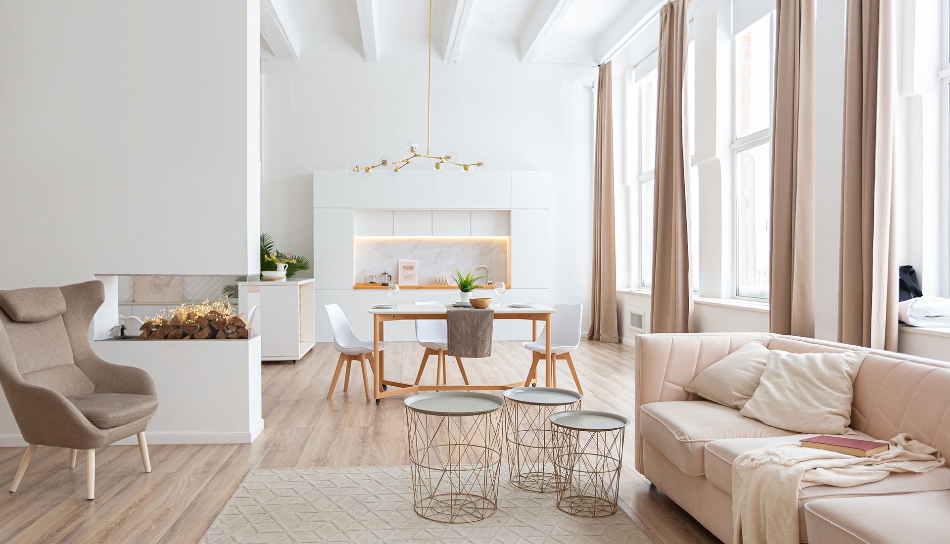 Bright white living space with kitchen, wooden floors, and beige accents.
