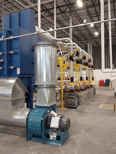 Blue industrial air filtration system in a factory setting.