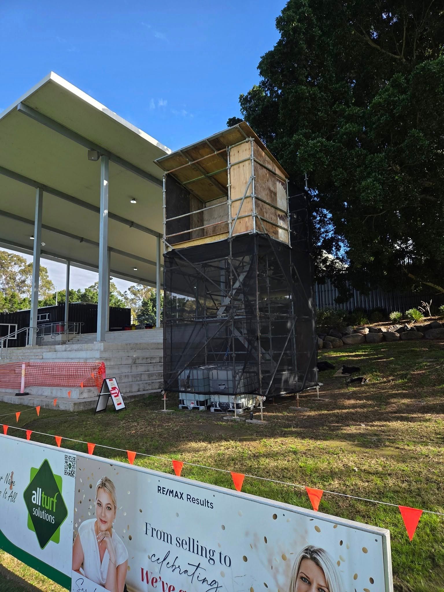 Construction Worker in Orange Shirt and White Hard Hat — Top Tier Scaffolding in Underwood, QLD