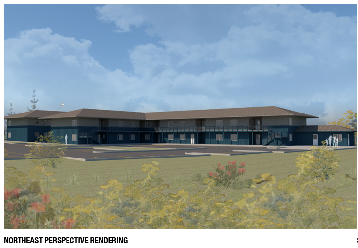 Two-story apartment buildings with angled roofs connected by a walkway, set against a green landscape.