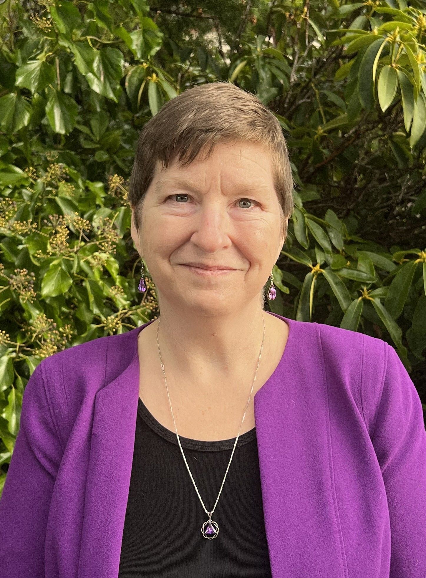 Lighthouse, home, and seagull silhouette in an orange and blue circular design, representing a coastal property.