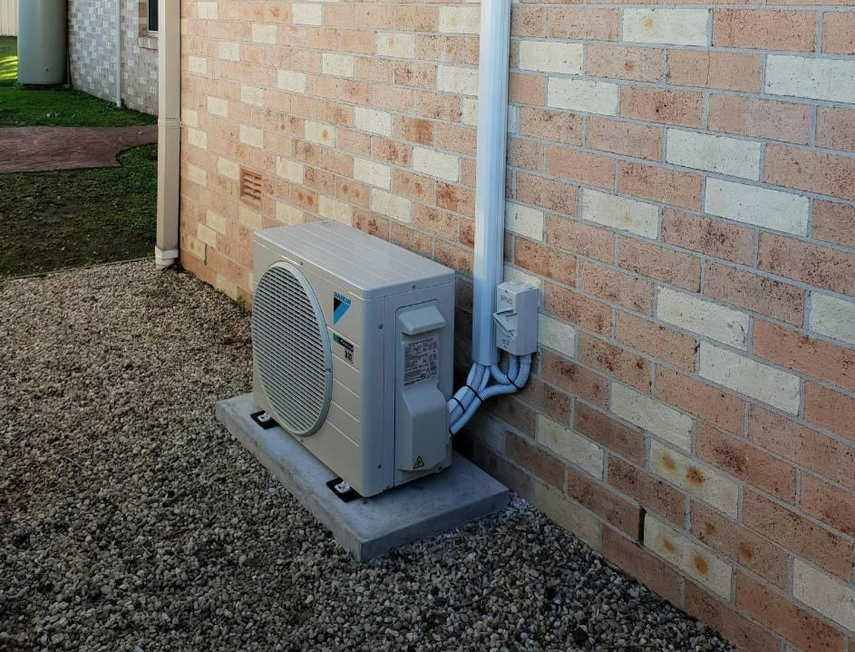 A Daikin Air Conditioner Is Mounted On The Side Of A Brick Building — Jervis Bay Airconditioning In Huskisson, NSW