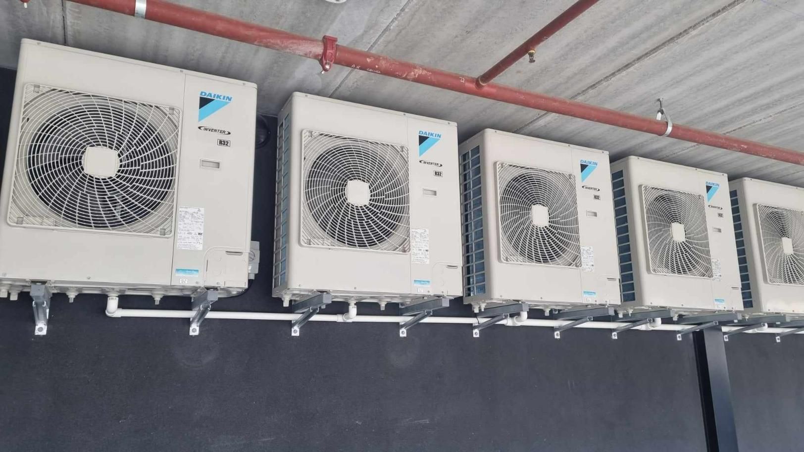 A Row Of Air Conditioners Hanging From The Ceiling Of A Building — Jervis Bay Airconditioning In Kemblawarra, NSW