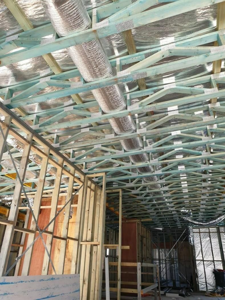 The Ceiling Of A Building Under Construction With A Lot Of Wooden Beams — Jervis Bay Airconditioning In Huskisson, NSW