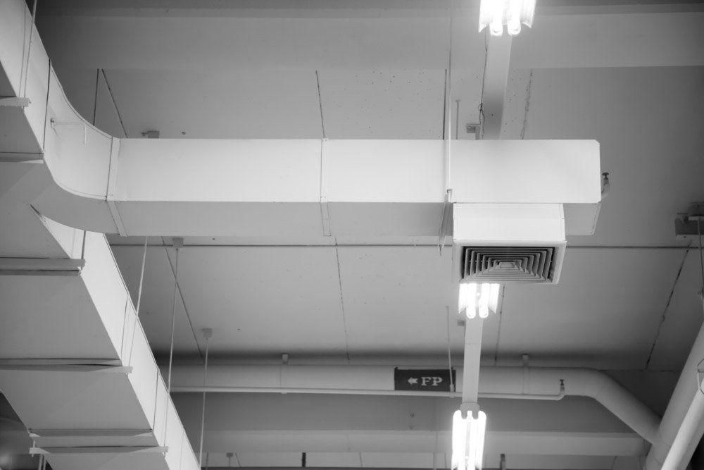 A Black And White Photo Of A Ceiling With A Lot Of Pipes Hanging From It — Jervis Bay Airconditioning In Huskisson, NSW