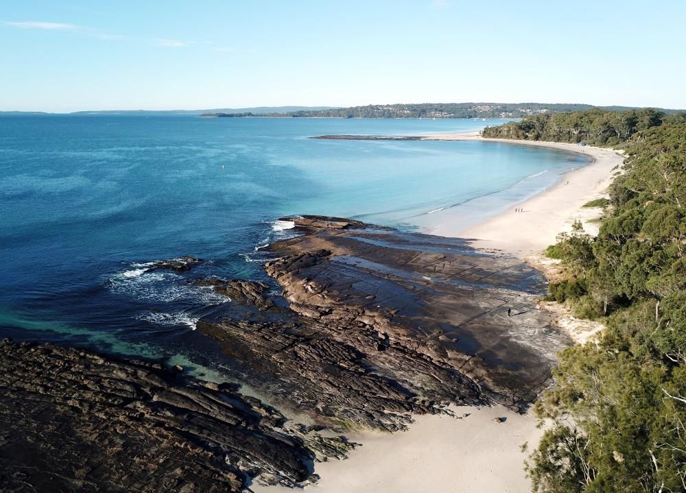 An Aerial View Of A Beach Surrounded By Rocks And Trees — Jervis Bay Airconditioning In Huskisson, NSW