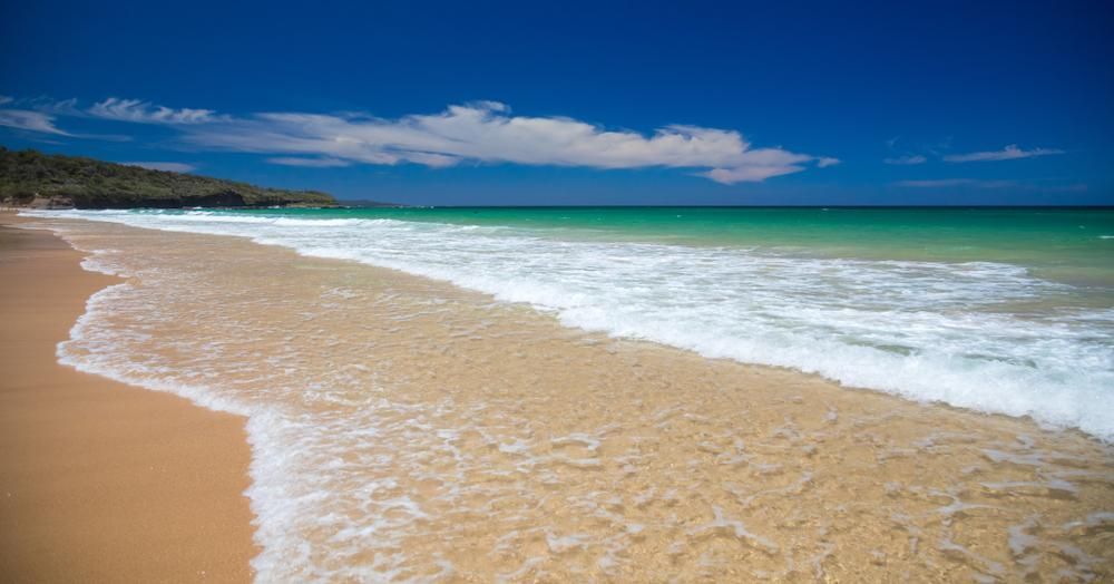 A Beach With Waves Crashing On The Sand On A Sunny Day — Jervis Bay Airconditioning In Sussex Inlet, NSW