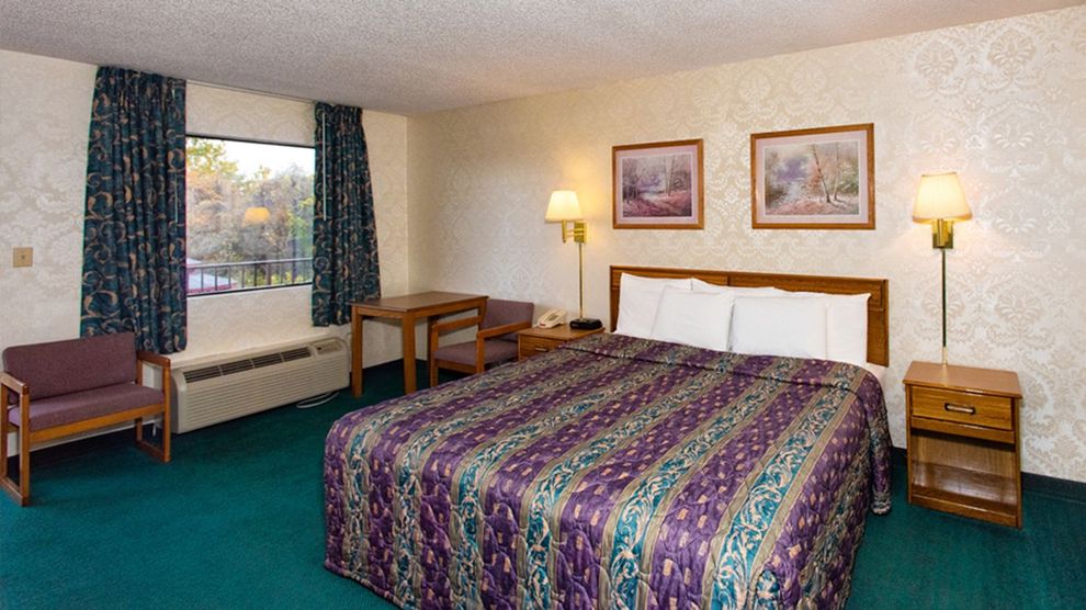 a hotel room with a king size bed and two chairs