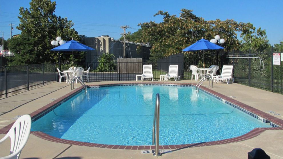 a large swimming pool with chairs and umbrellas around it