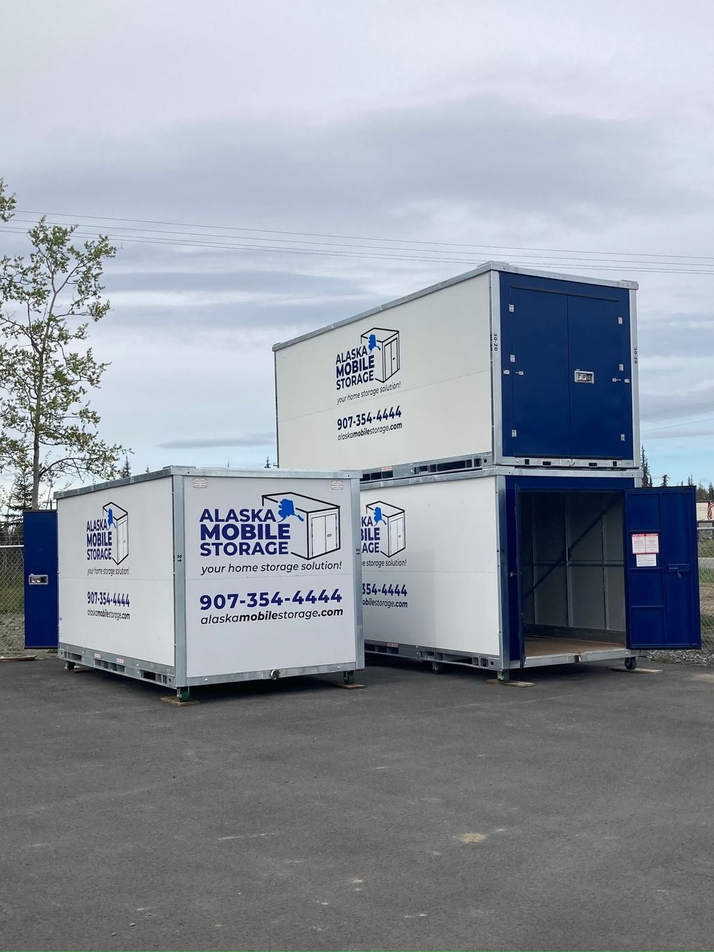 Two storage containers are stacked on top of each other in a parking lot.