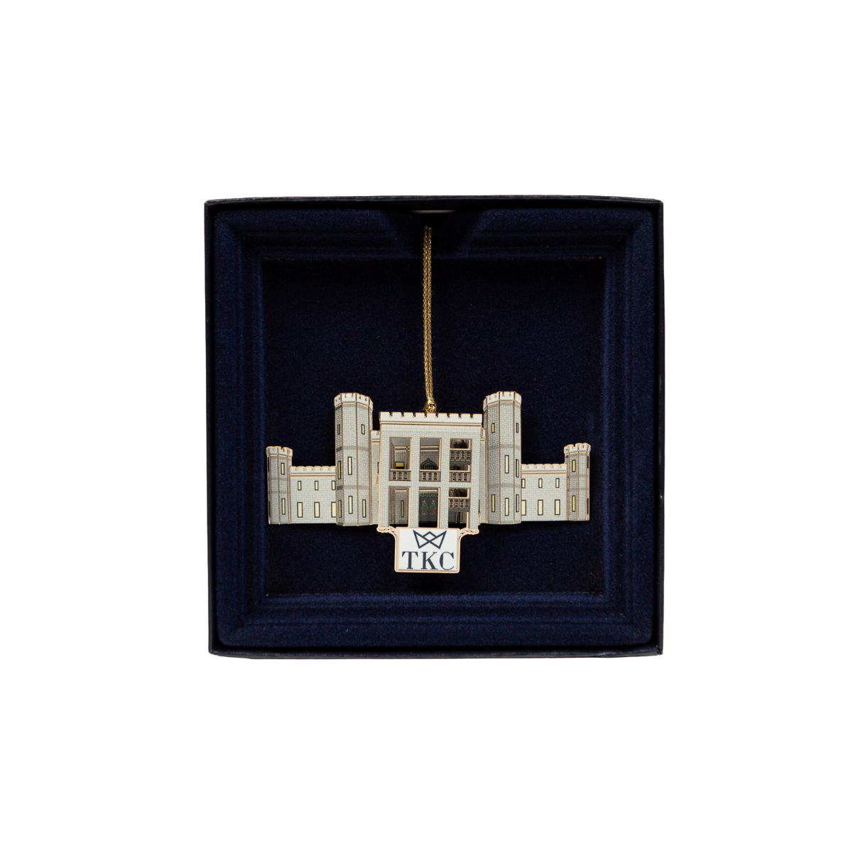 Ornament of a white building in a dark blue box with a gold hanging string.  "TKC" is at the bottom.