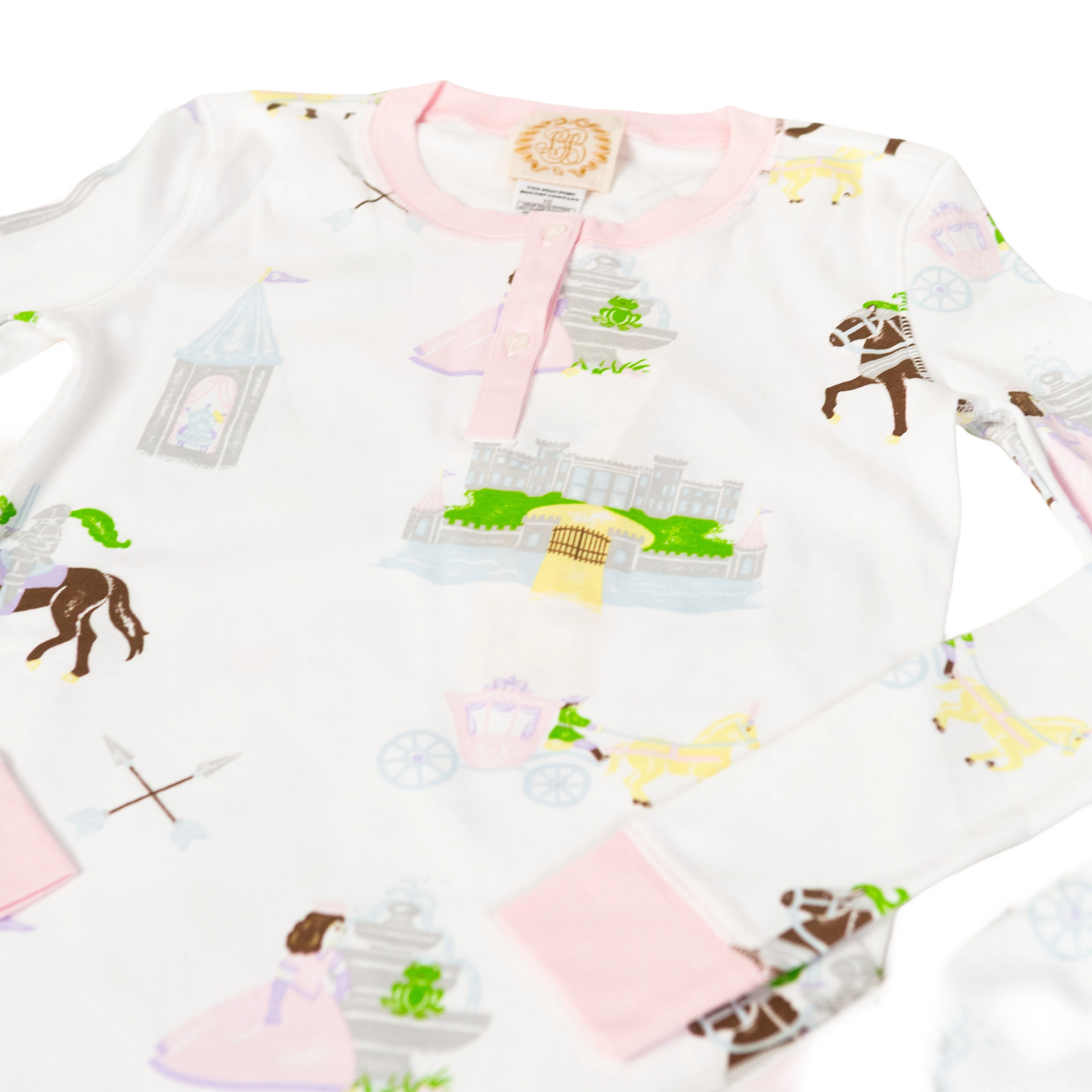 White pajamas with a horse and castle print, trimmed with pink.