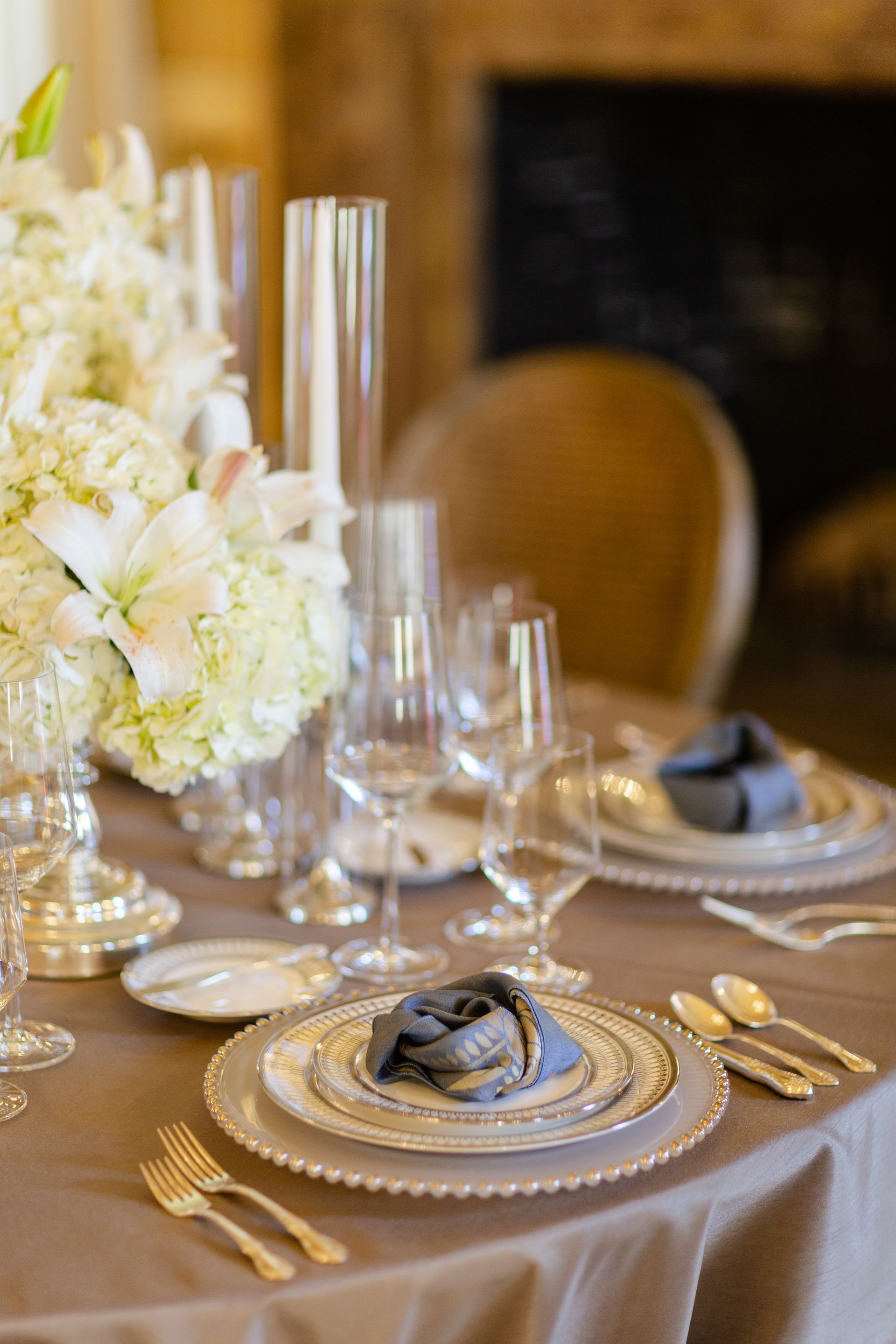 Elegant table setting with floral centerpiece, fine china, and silver cutlery.