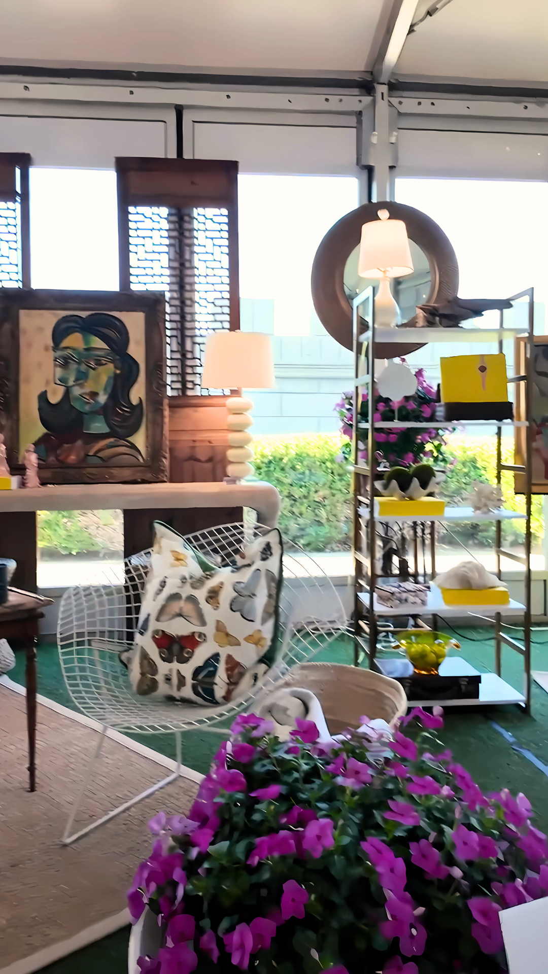 Interior design display with art, furniture, and flowers; neutral colors with pops of yellow and pink.