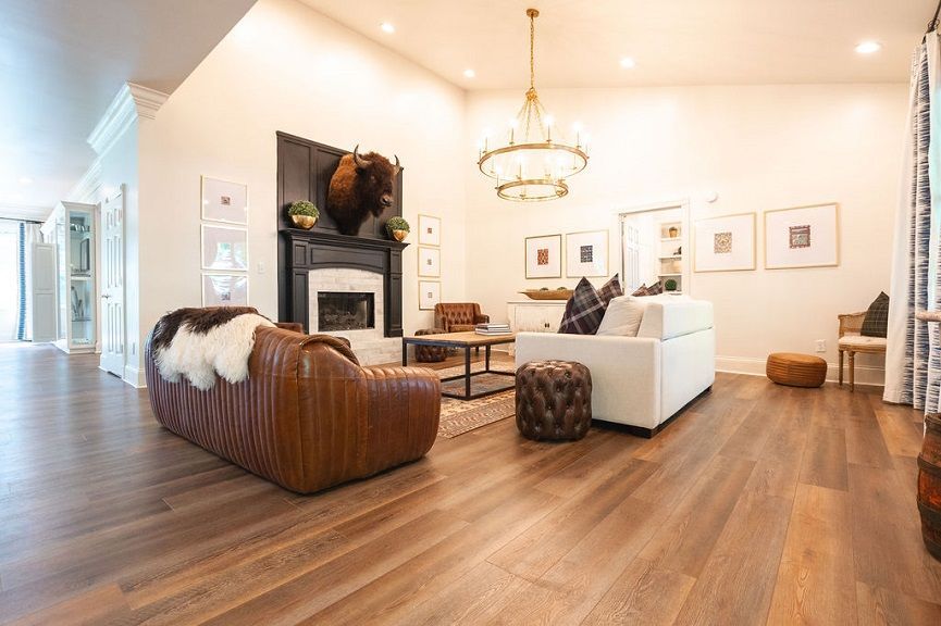 Living room with leather sofa, fireplace, and chandelier.