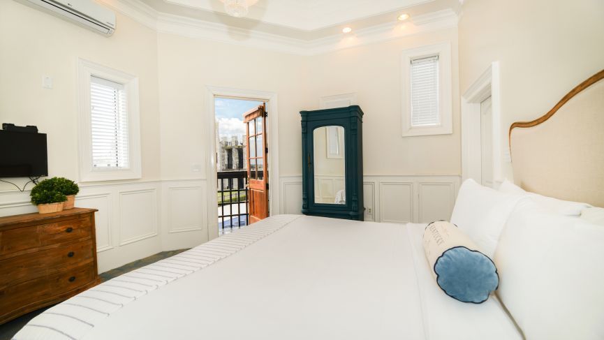 Bedroom with a bed, dresser, and blue wardrobe. Doorway leads to an outdoor area.