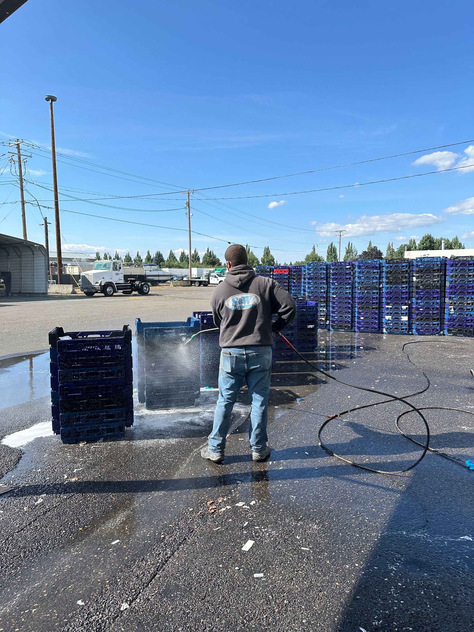 Truck being washed; water spraying on the front tire and cab, focusing on the details of the wheel and headlight.